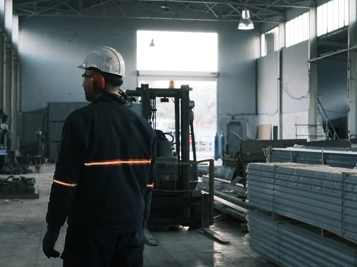 Supervisor con casco recorriendo una nave industrial